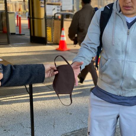 Gentleman handing another gentleman a mask