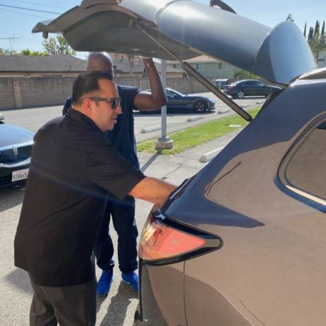 Two gentlemen looking in trunk