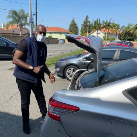 Man behind car with trunk open