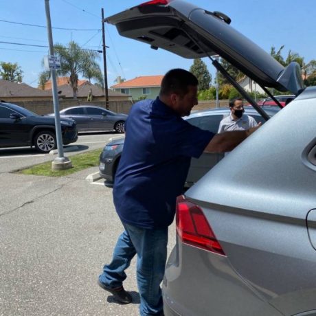 Man putting something in trunk of car