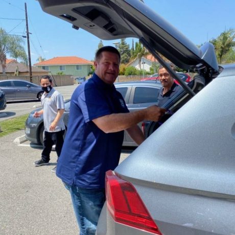 Man putting something in trunk of car