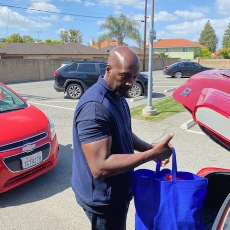 Man putting blue bag in trunk